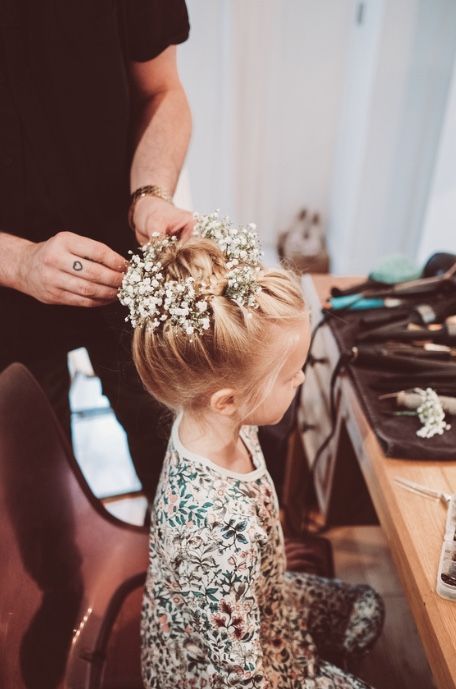 a braided top knot with fresh baby's breath tucked in is a super cool idea fro a flower girl