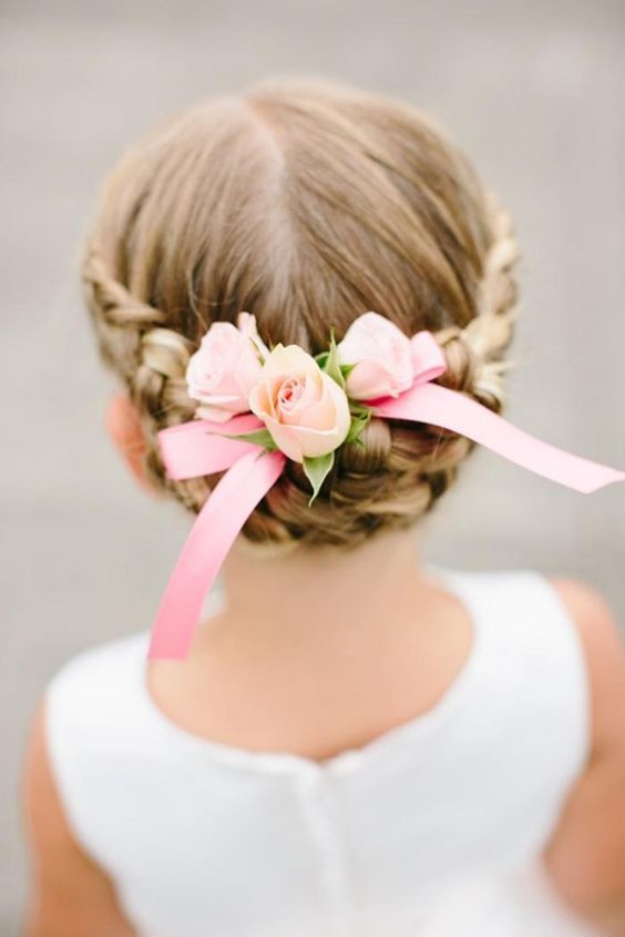 a braided updo with a halo and fresh pink roses is a cool and cute idea for a flower girl look, it's cute and chic