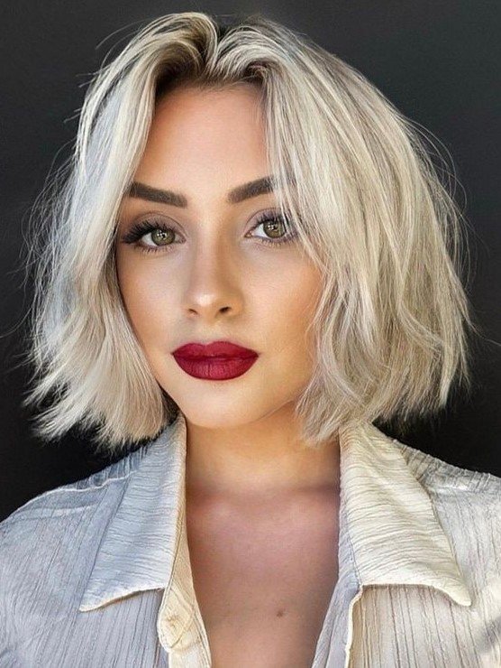 a chin-length icy blonde bob with a darker root and a lot of volume is a catchy and bold solution