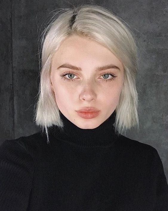 A chin length platinum blonde bob with a darker root and some volume is a bold solution that wows