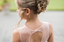 a curly updo with a bump on top and waves down is a lovely idea for a flower girl with medium length hair