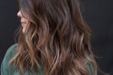 a dark brunette medium length haircut with an ombre effect, waves and volume is a very eye-catching idea