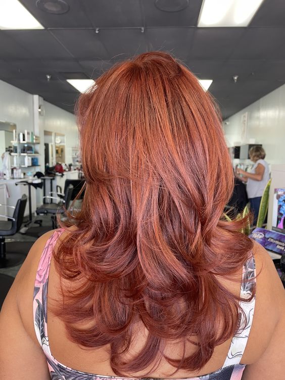 a gorgeous long red butterfly haircut with a lot of volume and curled ends is a very eye-catching and statement-like idea