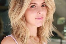 a lovely blonde shoulder-length hairstyle with a shadow root and waves, with side bangs and lots of dimension is amazing