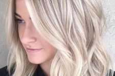 a lovely icy blonde shoulder-length haircut with waves and a bit of volume is a stylish and chic solution