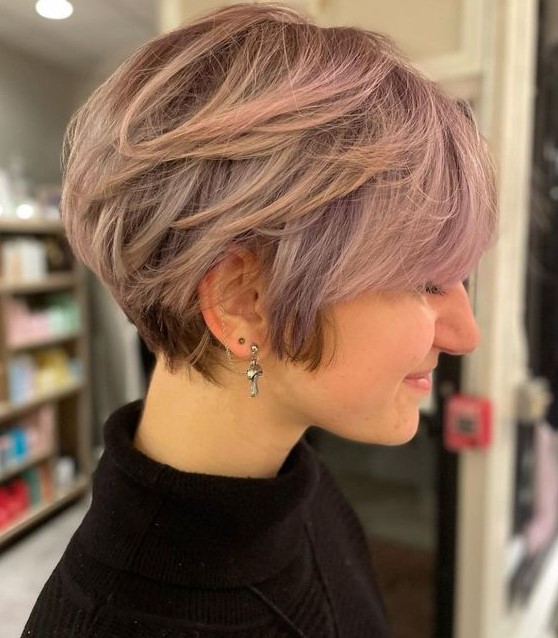 a lovely layered pink pixie bob with longer sides and side bangs is a very cool and lovely idea with a soft touch of color