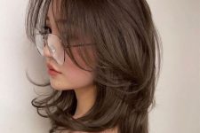 a lovely medium brunette haircut with a lot of volume and wispy bangs plus curled ends is a stylish idea