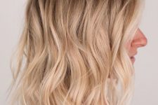 a lovely medium-length hairstyle with a shadow root and shiny blonde waves plus volume is amazing