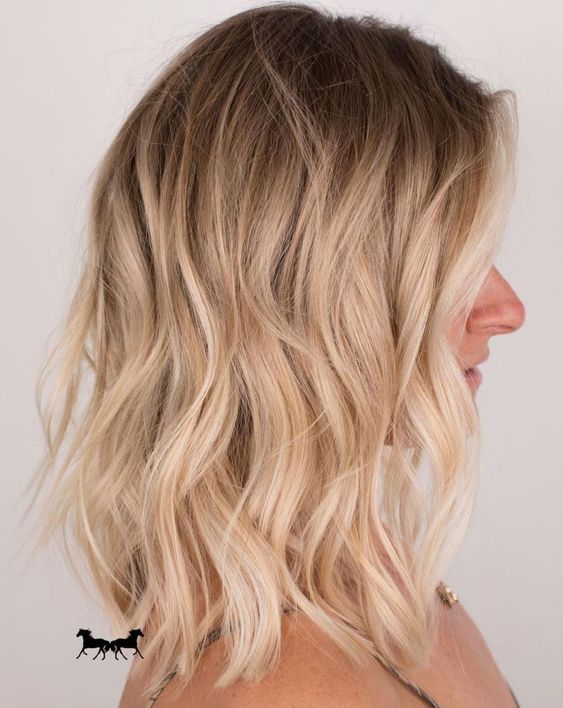 A lovely medium length hairstyle with a shadow root and shiny blonde waves plus volume is amazing