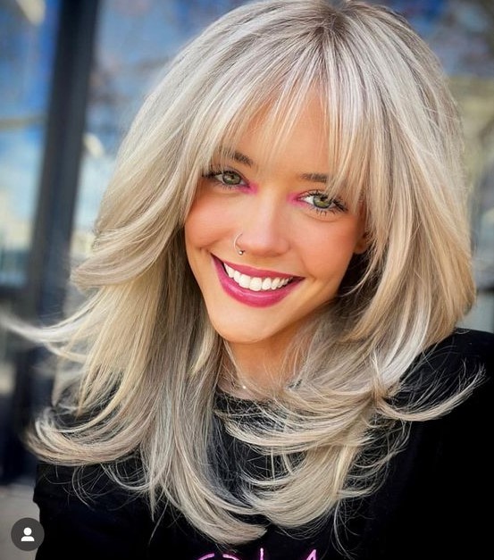 a medium blonde butterfly haircut with a lot of volume and curled ends is a very chic and beautiful idea