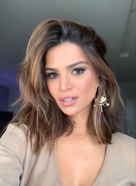 A medium length brunette haircut with golden blonde highlights and a lot of volume is a stunning idea