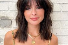 a medium length dark brown haircut with waves and wispy bangs is a cool idea that doesn’t require much maintenance