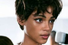 a messy and shaggy black pixie haircut with bottleneck bangs and slight waves is a lovely and cool solution