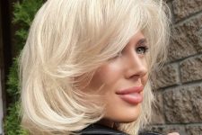 a midi platinum blonde bob with side bangs and curled ends plus a lot of volume looks a bit retro and chic