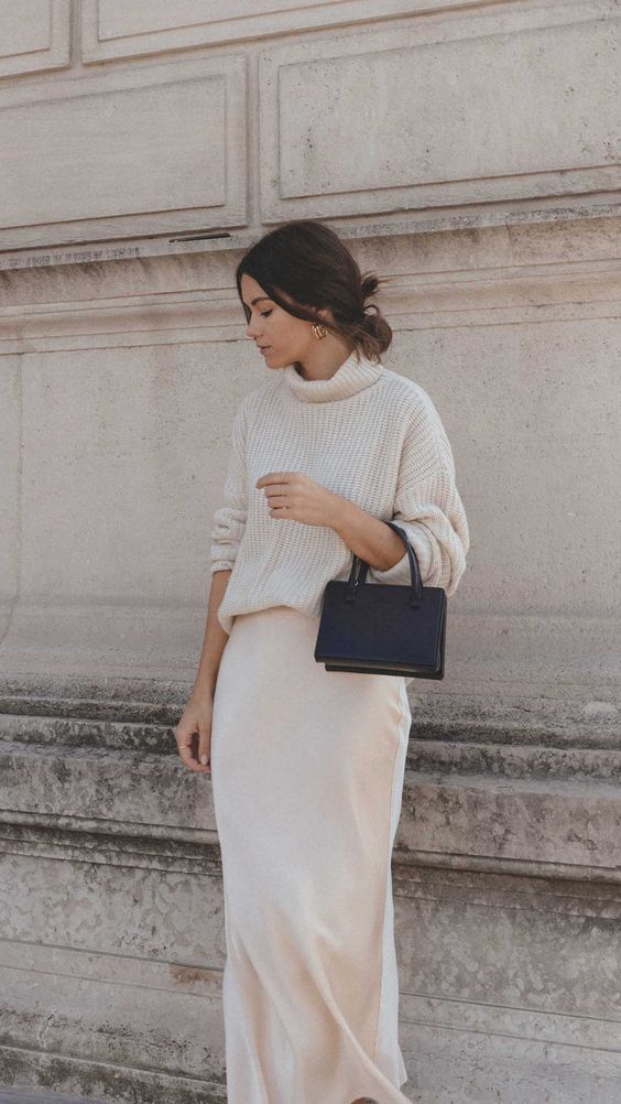 a pretty and simple bridal shower look with a sweater, a silk slip skirt, a black mini bag and statement earrings