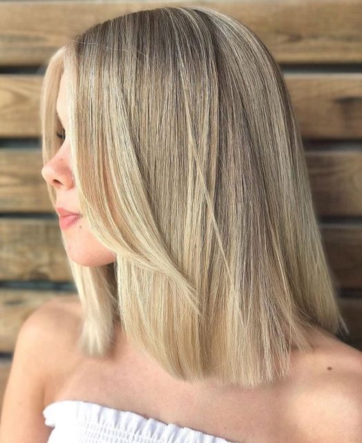 A refined soft blonde medium length hairstyle with face framing hair and straight texture is amazing