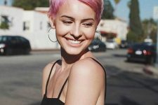 a shiny pink pixie haircut with side parting and volume looks amazing, bold and chic