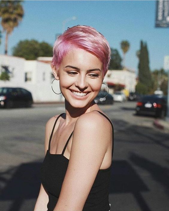 a shiny pink pixie haircut with side parting and volume looks amazing, bold and chic