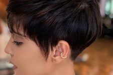 a short black pixie haircut with bangs and long side plus volume is a stylish and catchy idea to rock