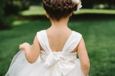 a side braid wrapping the head, with some fresh white blooms, is a chic idea for a formal flower girl look