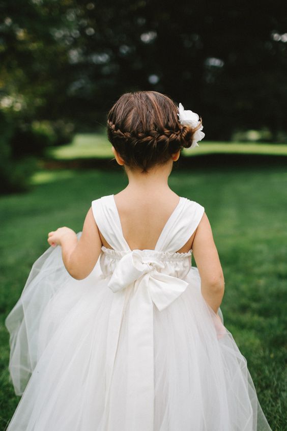 a side braid wrapping the head, with some fresh white blooms, is a chic idea for a formal flower girl look
