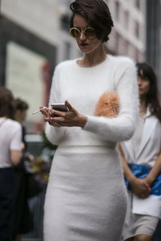 A simple and stylish modern bridal shower look with a fine knit white angora sweater with a scoop neck and a skirt, a fluffy bag is a cool solution for a modern bride to be