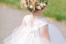 a simple high ponytail with a bit of messy hair and a flower crown is a cool idea for a romantic and chic flower girl look