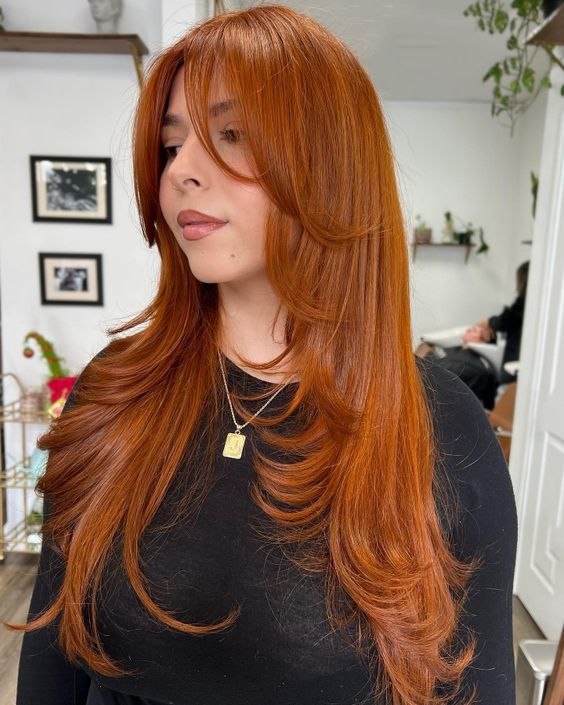 a stunning bright copper long butterfly haircut with face-framing layers and curled ends is amazing