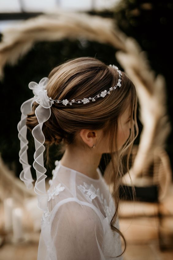 a top knot, a bump, some locks down and a flower and bead crown with a bow and long ribbon is a cool idea for a flower girl