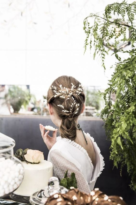 a twisted and braided ponytail with a bump on top, with a beaded hair vine is an elegant and chic idea for a flower girl