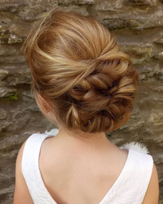 a twisted low updo with a bump on top is a chic idea for a flower girl with long hair that is also thick