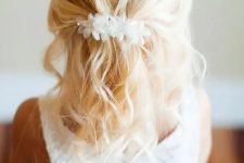 a wavy half updo with a voulminous bump, with waves down and a white silk flower hairpiece is a lovely idea that always works