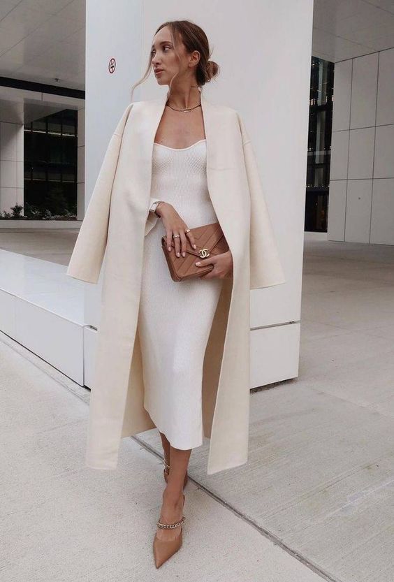 a white midi dress, a neutral coat, beige chain shoes, a small brown bag for a refined winter bridal shower look