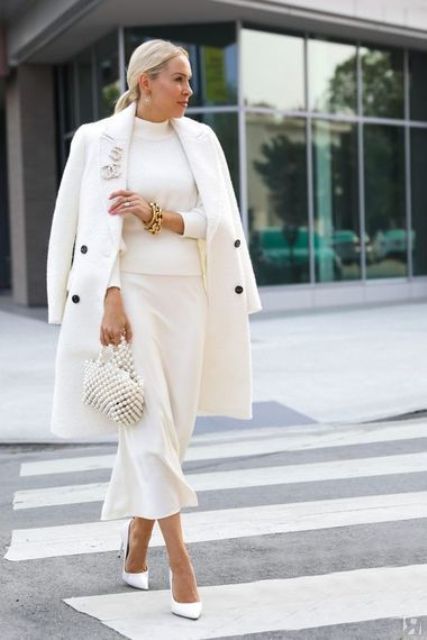 a white turtleneck, a slip midi skirt, white shoes, a white bag and an embllished bag and gold accessories
