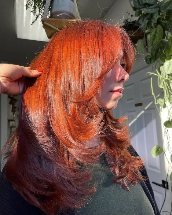 an amazingly bold and catchy red butterfly haircut on long hair, with curled ends and a lot of volume will strike everyone