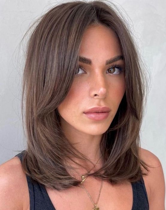 an elegant layered brunette haircut with curtain bangs and curled ends is a stylish idea to try right now