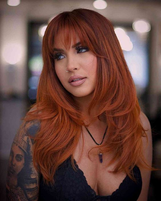 An extra bold long copper butterfly haircut is amazing to look jaw dropping, wispy bangs accent the eyes