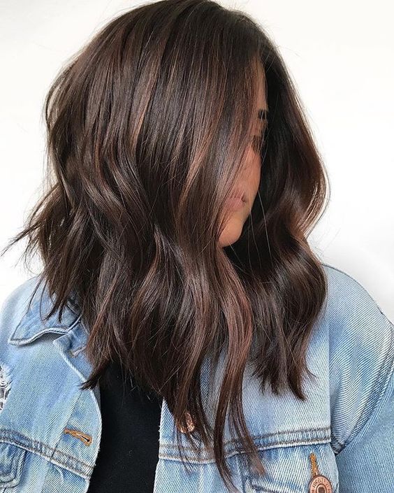 an inverted dark brunette haircut with waves and auburn highlights plus some volume is a chic and catchy idea for the fall
