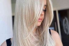beautiful platinum blonde medium-length hair with face-framing layers and curled ends is a chic hairstyle