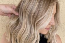 elegant medium-length blonde hair with brighter and darker locks, with a bit of waves and money piece is cool