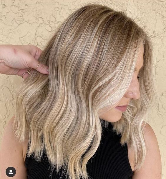 Elegant medium length blonde hair with brighter and darker locks, with a bit of waves and money piece is cool