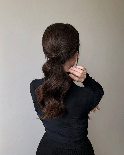 gorgeous chocolate brown hair done in a wavy low ponytail, with face-framing layers is a stylish solution