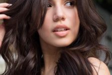 long and wavy chocolate brown hair without adding any other color touches looks chic and refined and flatters brunettes a lot