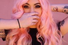 long and wavy pastel pink hair with side parting is a lot of fun and it looks bold and candy-inspired
