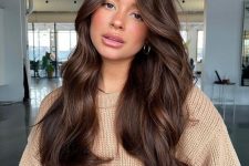 long chocolate brown hair with a lot of volume and waves, face-framing layers is a chic and cool idea to try