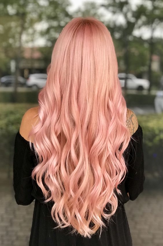 long peachy pink hair with waves and volume is a stylish and chic idea for anyone who loves warm shades