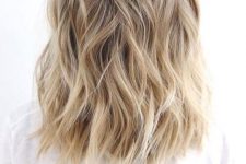 lovely medium-length blonde hair with a shadow root and waves, with volume, is a lovely idea to rock, it’s low-maintenance