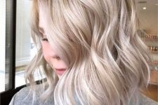 medium-length icy blonde hair with a bit of waves and volume is a stylish idea if you like cold shades of blonde