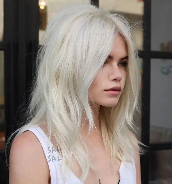 Medium length platinum blonde hair with messy layers, a lot of volume and a bit of texture is a cool and stylish idea to rock