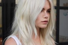 medium-length platinum blonde hair with messy layers, a lot of volume and a bit of texture is a cool and stylish idea to rock